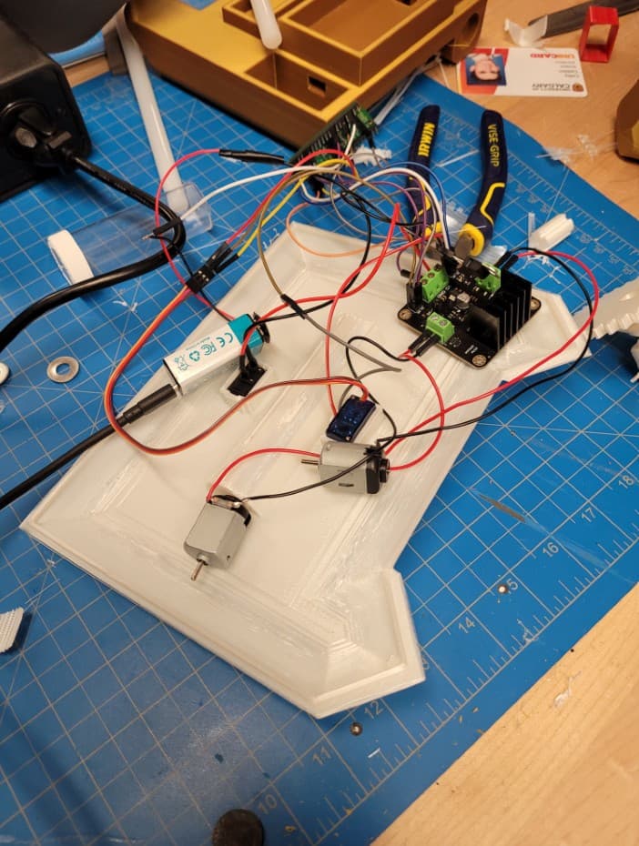 Motors, motor driver, and battery wired on a 3D-printed hull base