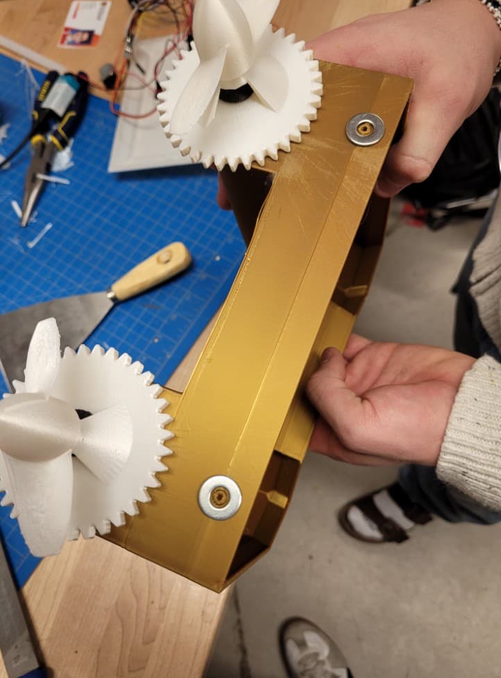 3D-printed geared propulsion assembly with twin propellers on a gold chassis