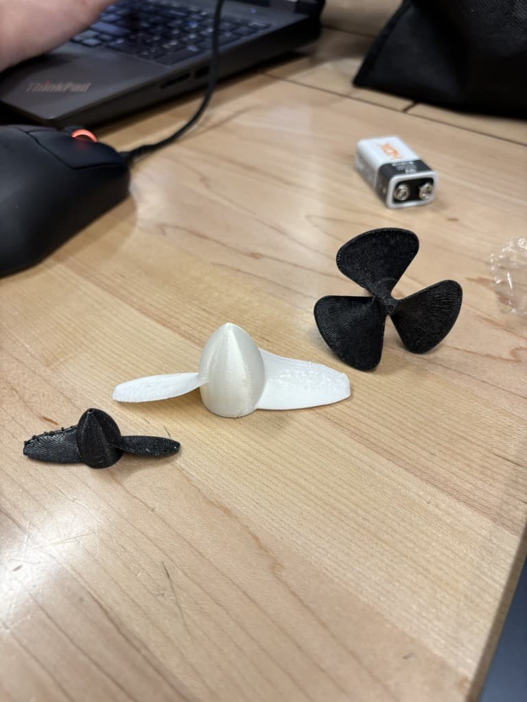Three 3D-printed propeller prototypes on a workbench